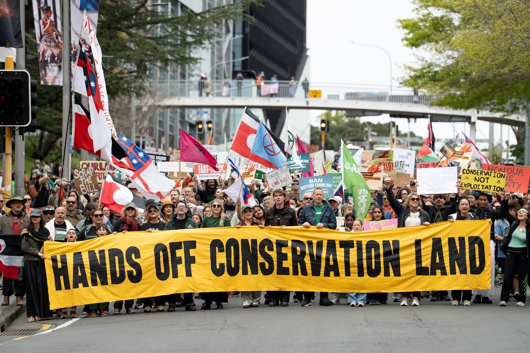 Marchers holding a Hands Off Conservation Land banner